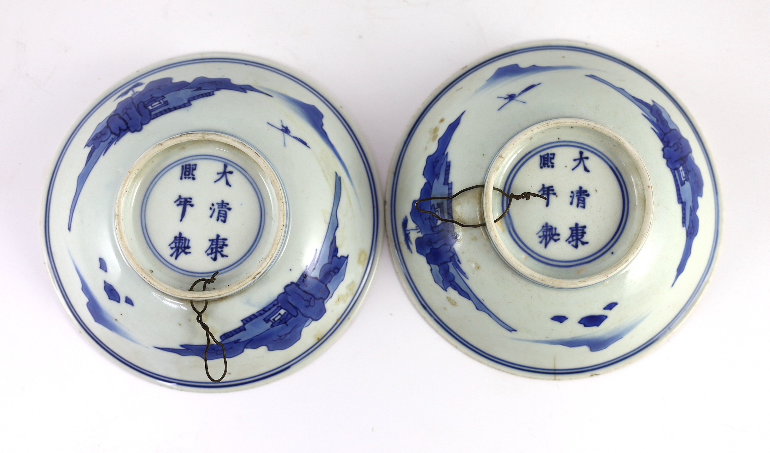 NB BOTH WITH HAIRLINE CRACKS A pair of Chinese blue and white small dishes, Kangxi six character marks and of the period (1662-1722), 15.7cm and 15.8cm diameter, foot later pierced, hairline cracks